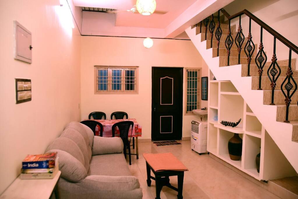 a living room with a couch and a staircase at Steve homestay, near white town, near rock beach in Pondicherry