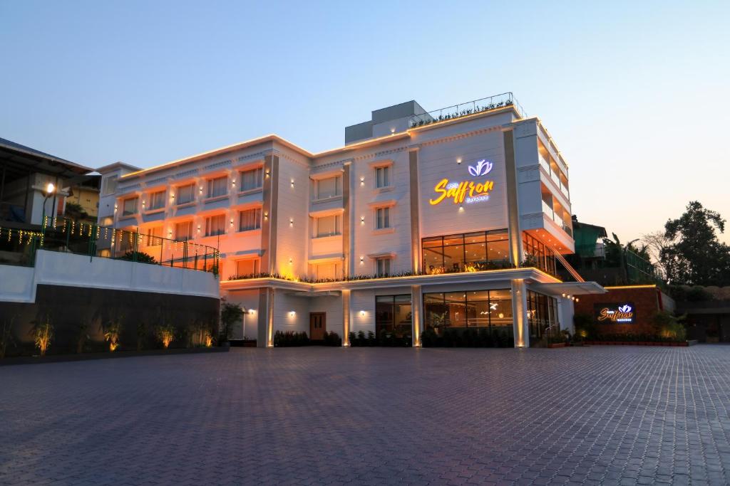 a large building with a sign on the front of it at Hotel Saffron Wayanad in Sultan Bathery