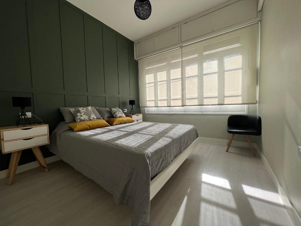 - une chambre avec un lit, une fenêtre et une chaise dans l'établissement Unique Aparment Mendoza, à Mendoza