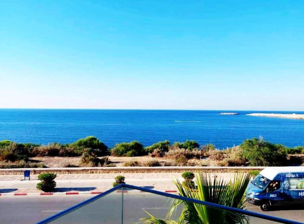 une camionnette garée dans un parking à côté de l'océan dans l'établissement Studio avec vue directe mer, à Monastir