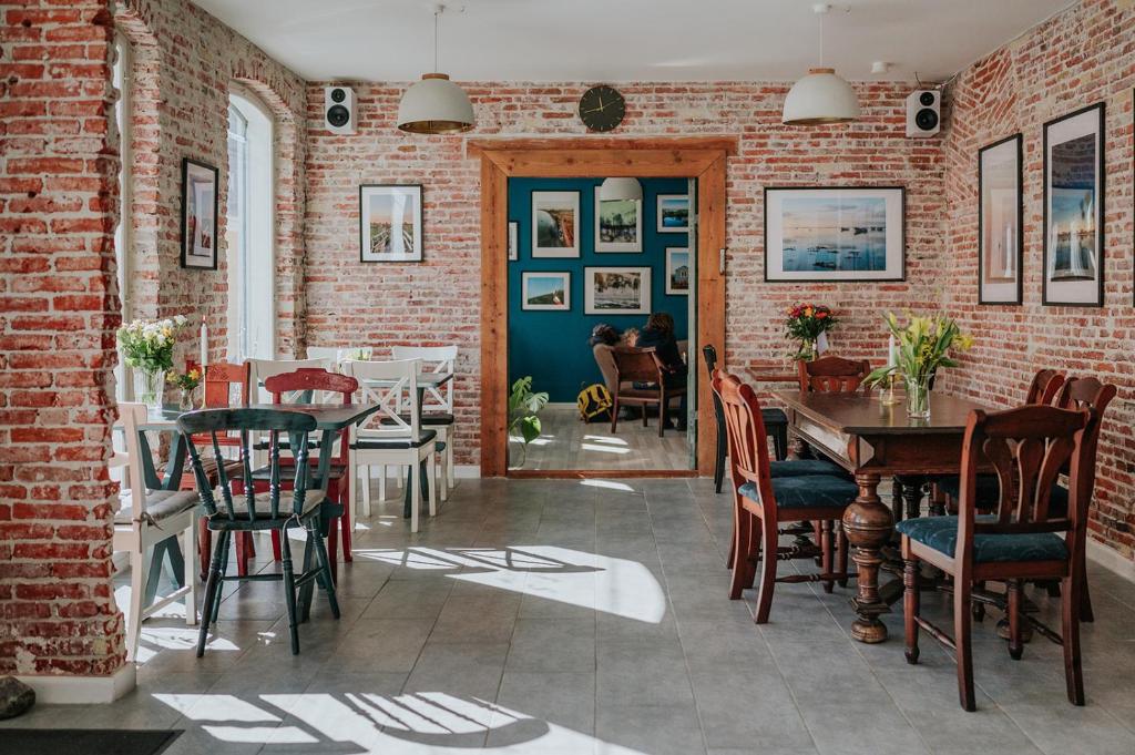 een eetkamer met een bakstenen muur en een tafel en stoelen bij KEFS Guesthouse & Café in Ærøskøbing