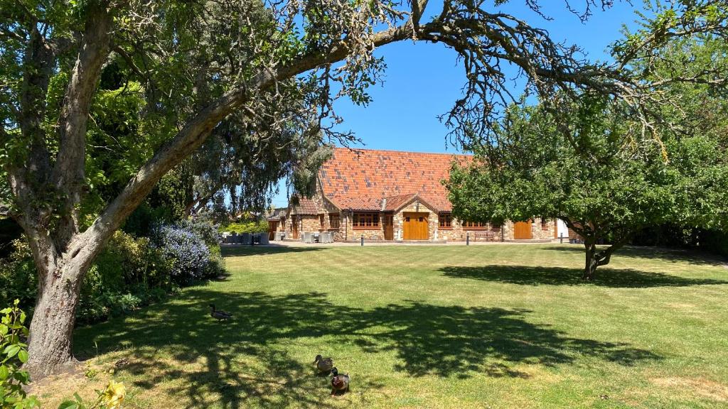 a house with a red roof and a yard with trees at Ye Olde Plough House 