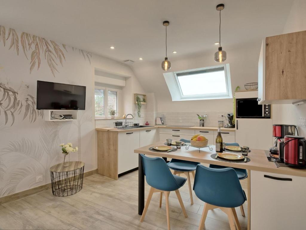 une cuisine avec une table et des chaises bleues. dans l'établissement Holiday Home Hoedic by Interhome, à Plouhinec