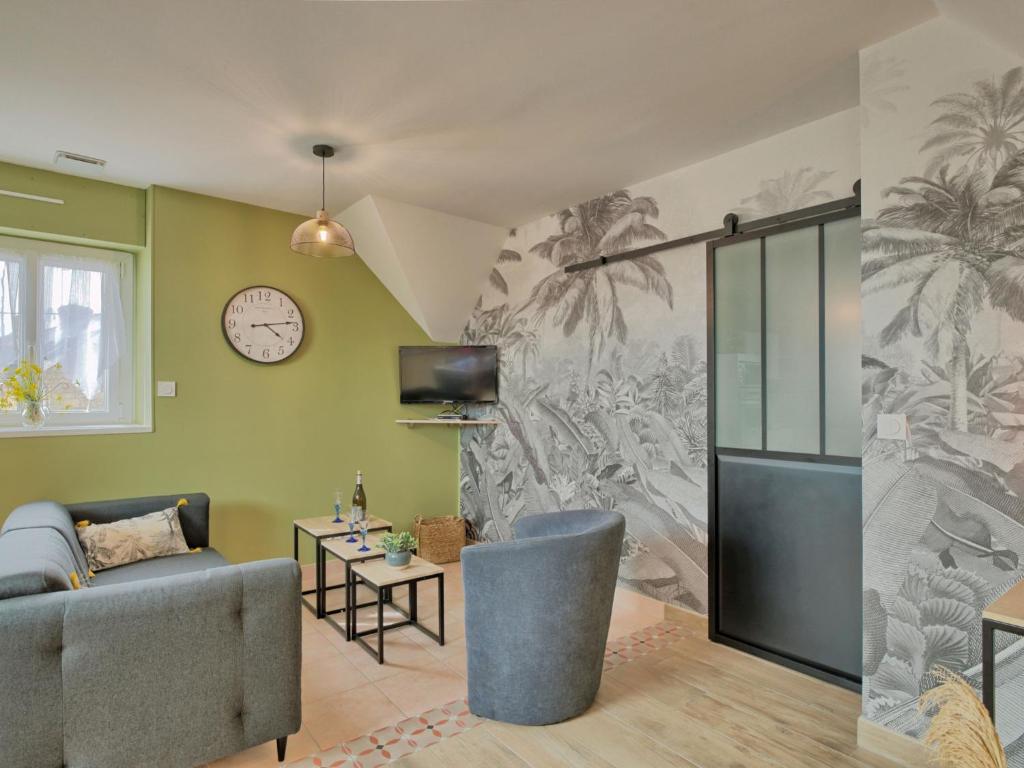 un salon avec un canapé et une horloge au mur dans l'établissement Holiday Home Groix by Interhome, à Plouhinec