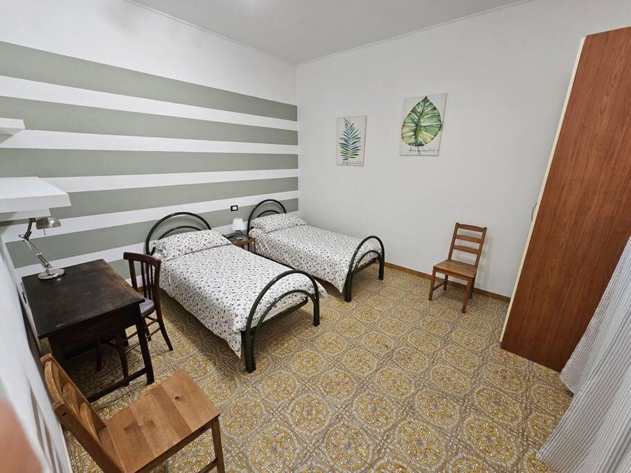 Zimmer mit 3 Stühlen, einem Tisch und einem Schreibtisch in der Unterkunft Cà Tosca in La Spezia