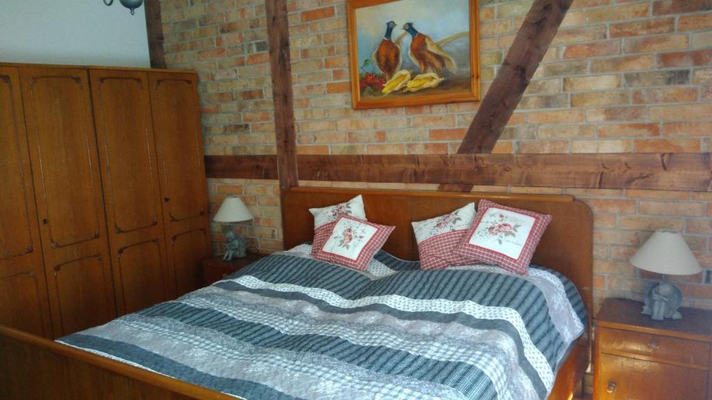 een slaapkamer met een bed met kussens erop bij Cztery Pory Lasu 