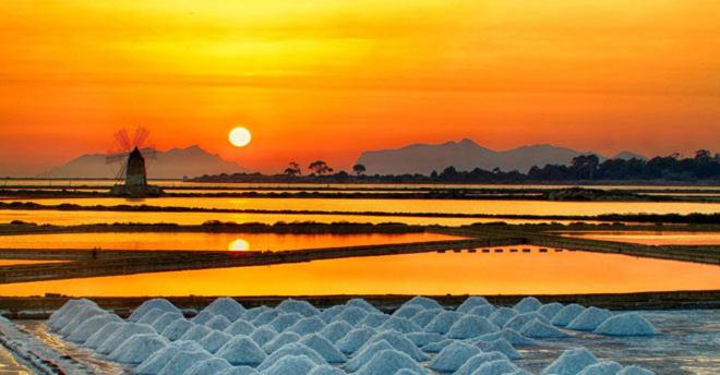 einen Sonnenuntergang über einem Wasserkörper mit Sonnenuntergang in der Unterkunft ZEFIRO in Marsala