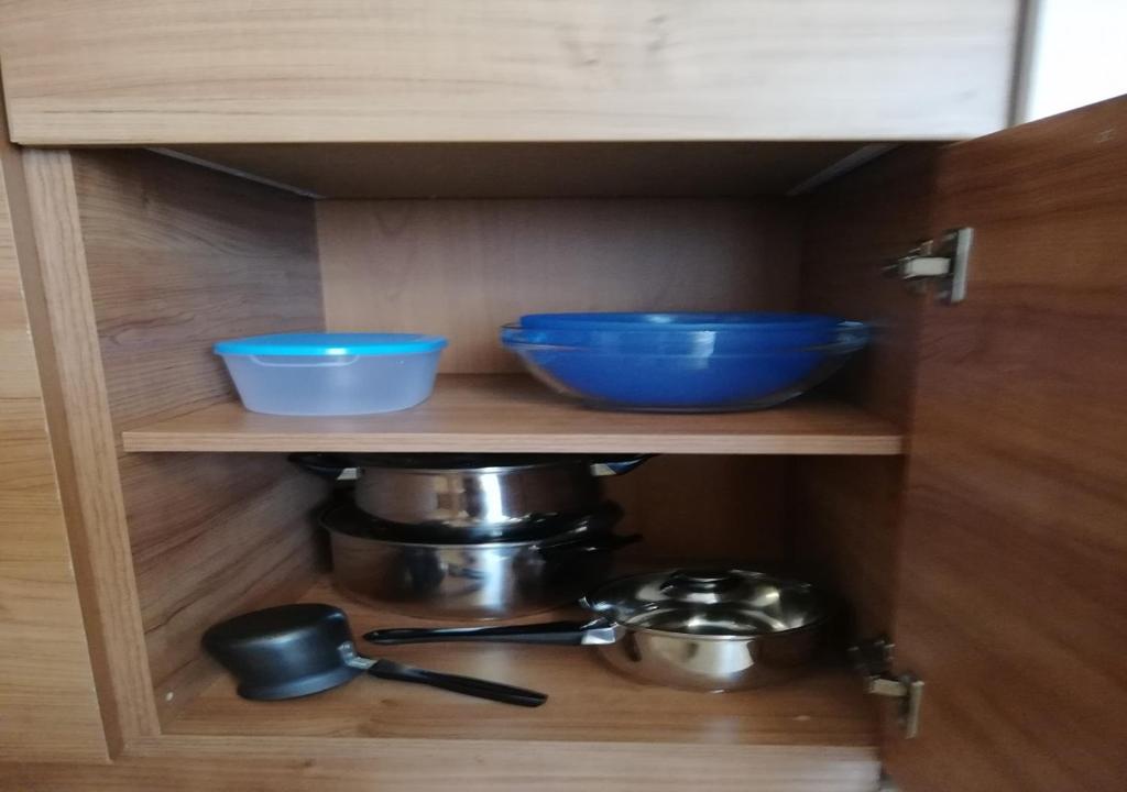 a cabinet with two bowls and pots and pans at Charis Cozy Family apart at Sun Village Complex close to the Beach in Sunny Beach