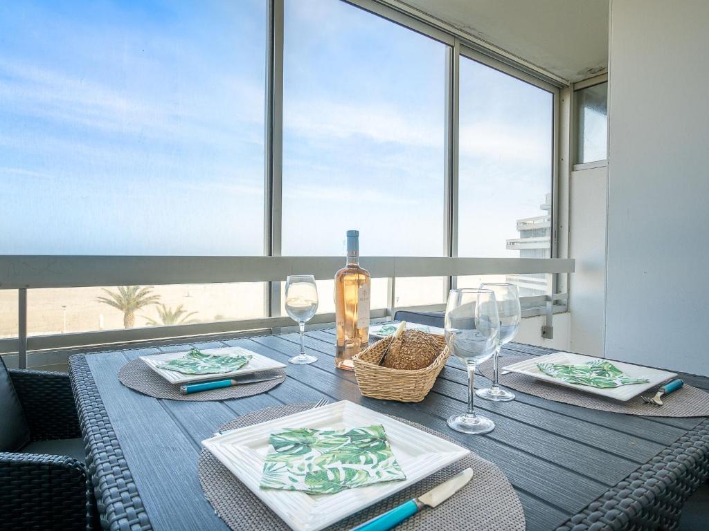 Una mesa de comedor con una botella de vino y copas. en Apartment Les Trois Mâts-4 by Interhome, en Canet-en-Roussillon