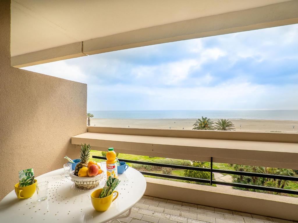 d'un balcon avec une table et une vue sur la plage. dans l'établissement Apartment Les Terrasses du Levant-5 by Interhome, à Canet