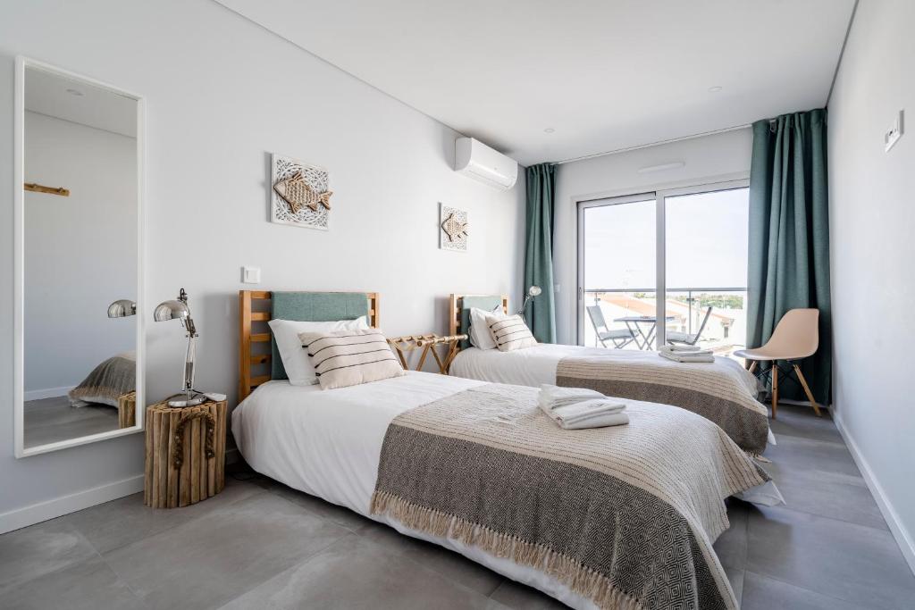 due letti in una stanza con finestra di Coastal Holiday´s Apartment a Monte Gordo