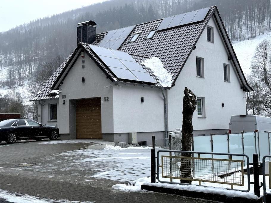 a white house with a garage in the snow at Haus an der Sieber Zimmer 4 in Herzberg am Harz