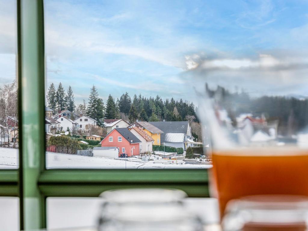 a glass of beer sitting in front of a window at Apartment Bergliebe - G 103 by Interhome in Dittishausen