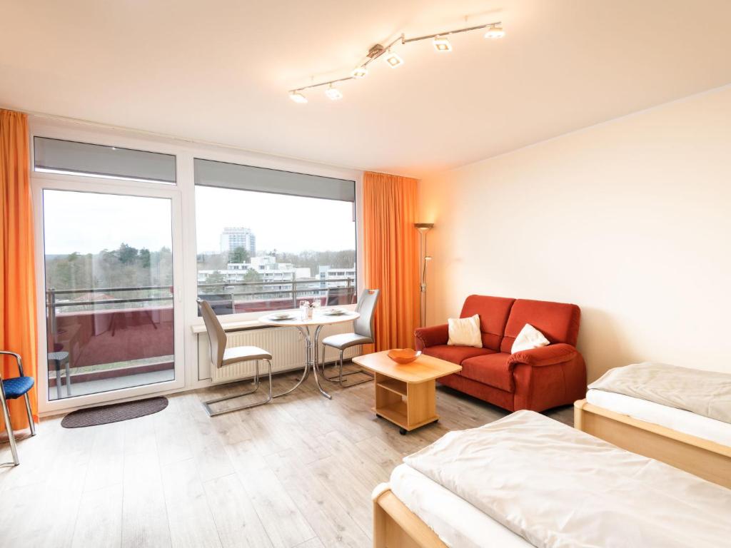 ラーンシュタインにあるApartment B806 by Interhomeのベッド、テーブル、ソファが備わるホテルルームです。