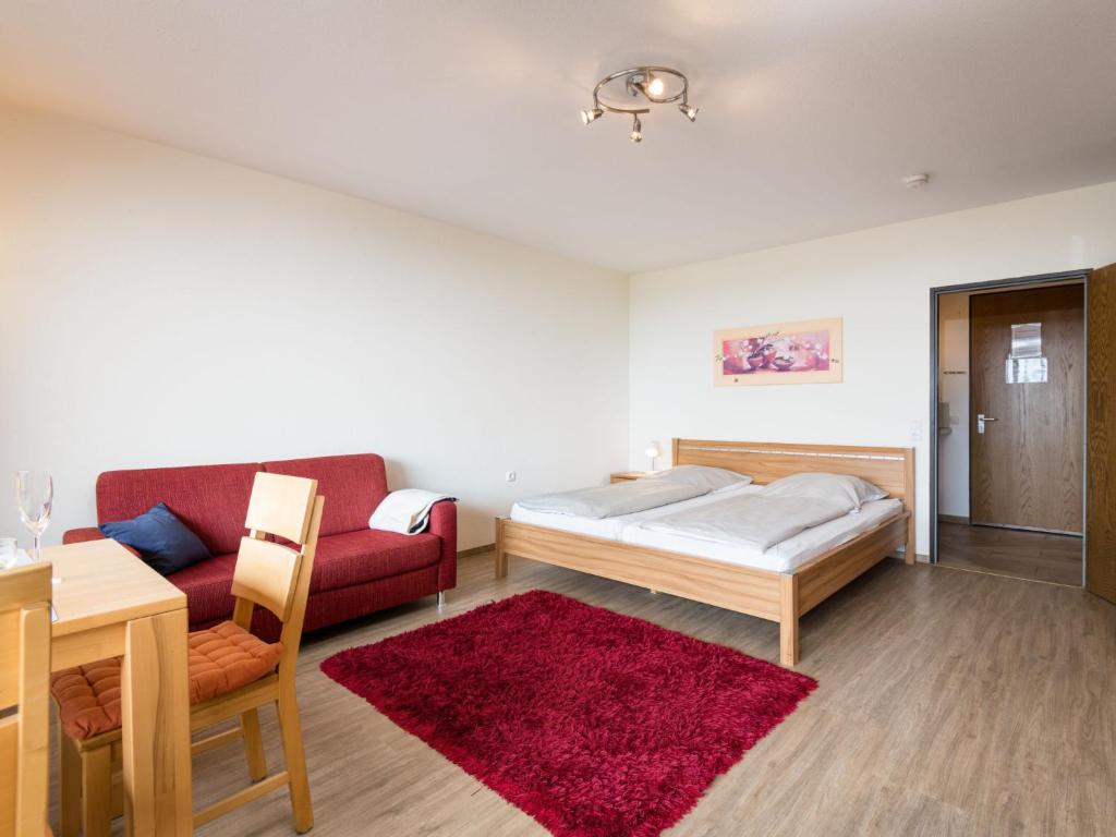 1 dormitorio con cama, sofá y mesa en Apartment B906 by Interhome, en Lahnstein
