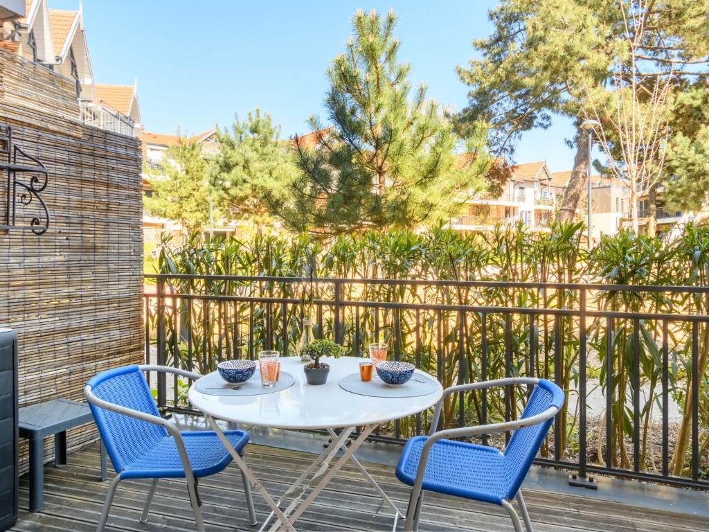 une table et des chaises sur une terrasse avec une clôture dans l'établissement Apartment Couleurs Tchanquées-1 by Interhome, à Arcachon