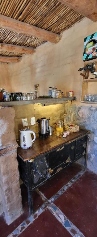 a kitchen with a wooden table with a stove at Pacha Cuty Hostel in Amaichá del Valle