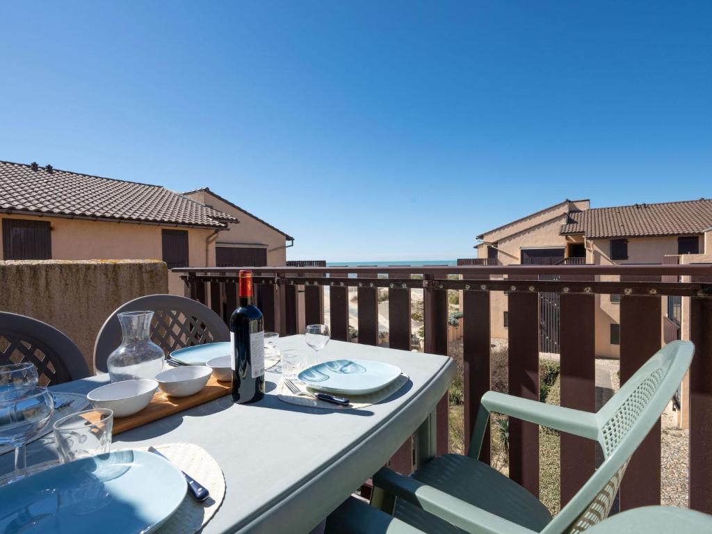- une table avec une bouteille de vin sur le balcon dans l'établissement Apartment Les Maisons de l'Océan-11 by Interhome, à Lacanau-Océan