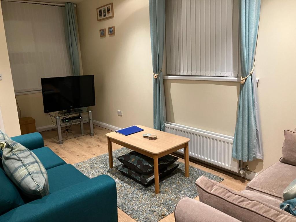 a living room with a blue couch and a table at Causeway Street Holiday House Self Catering-Portrush in Portrush