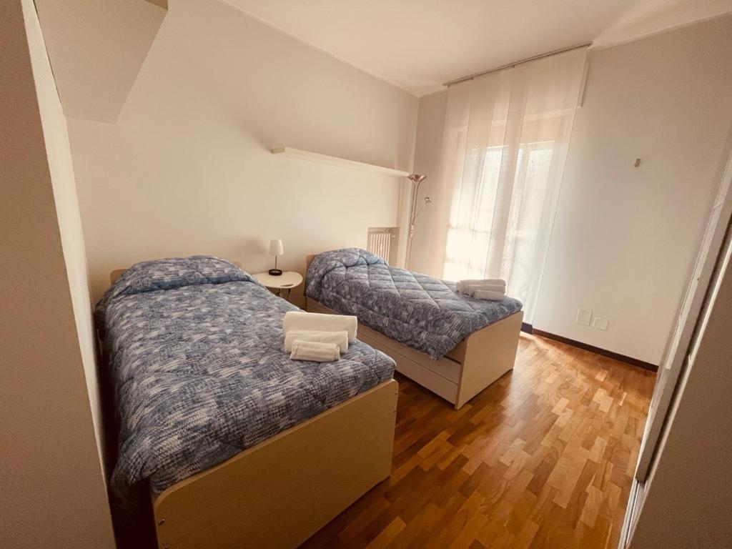 two beds in a small room with wood floors at CasaPratti Pescara centro in Pescara