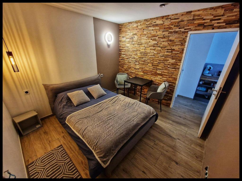 - une chambre avec un lit et un mur en briques dans l'établissement Chambre proche Puy du fou entrée indépendante, Encas du matin Offert, à Bazoges-en-Paillers