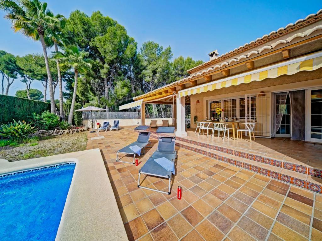 eine Terrasse mit Stühlen und einem Pool in der Unterkunft Holiday Home La Sal by Interhome in Moraira