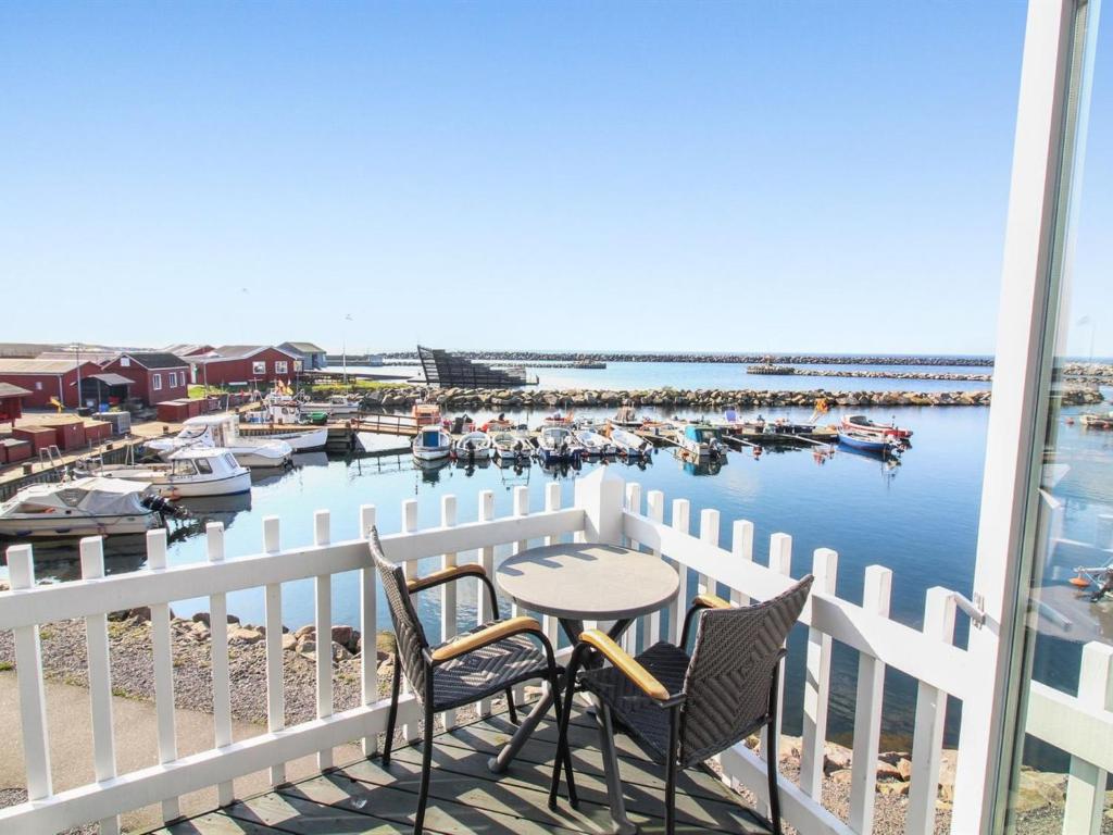 a balcony with a table and chairs and a marina at Holiday Home Allette - 10m from the sea in Bornholm by Interhome in Hasle