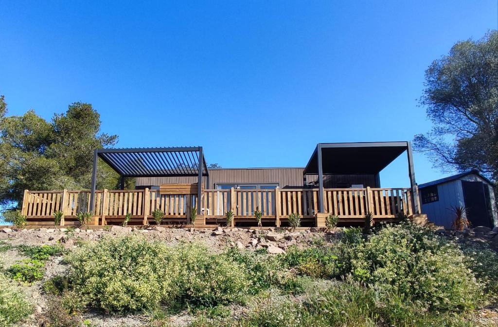 une maison avec une terrasse en bois et un bâtiment dans l'établissement LUXUEUX MOBIL-HOME, à Pierrefeu-du-Var