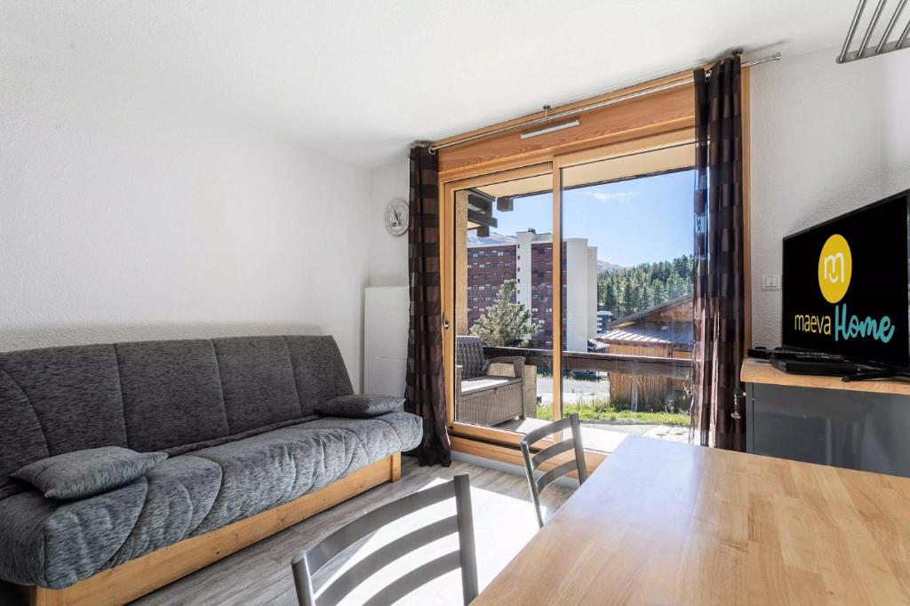 een woonkamer met een bank en een tafel bij Les Alpages de Vars - maeva Home in Vars