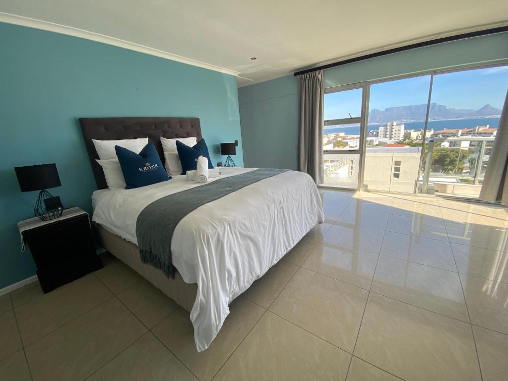 a bedroom with a large bed and a large window at Imany Guest House in Bloubergstrand