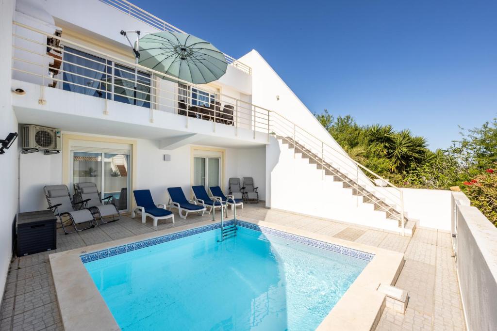 uma villa com uma piscina e uma casa em Casa Melancia na Praia da Luz