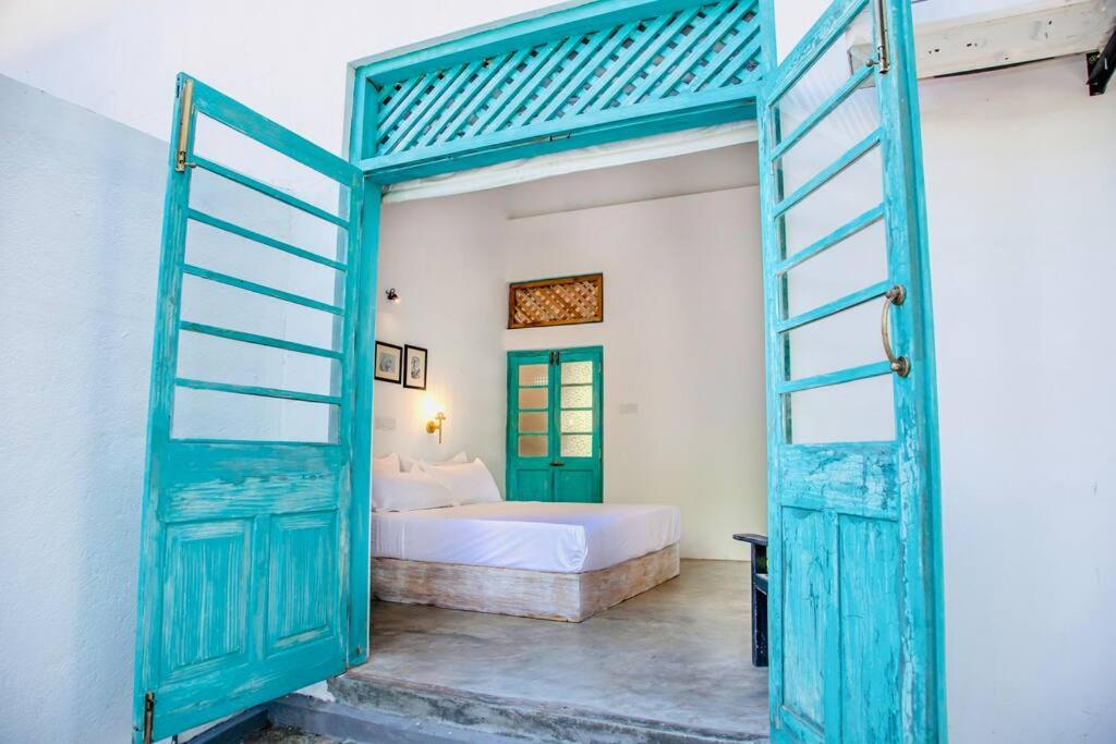 a bedroom with a bed and an open door at Mawella House 1807, Tangalle in Tangalle