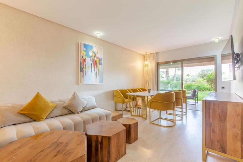 uma sala de estar com um sofá e uma mesa em Résidence Golfique PJ, jardin, piscine em Marrakech
