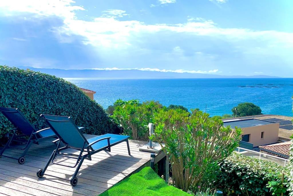 patio z krzesłami i oceanem w tle w obiekcie Ajaccio maison bord de mer dans résidence avec piscine w Ajaccio