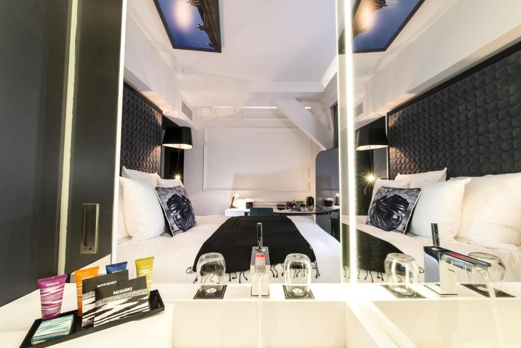a hotel room with a bed and a mirror at Vertigo Hotel, By Marriott, a Member of Design Hotels in Dijon