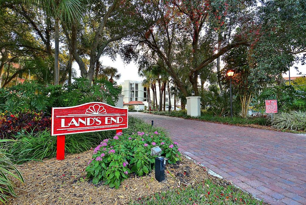 a sign that says lands end in a garden at Land's End 4-306 Bay Front - Premier in St. Pete Beach