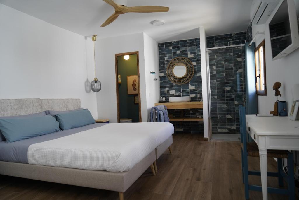 Schlafzimmer mit einem Bett, einem Schreibtisch und einem Waschbecken in der Unterkunft La Pecera Altea in Altea