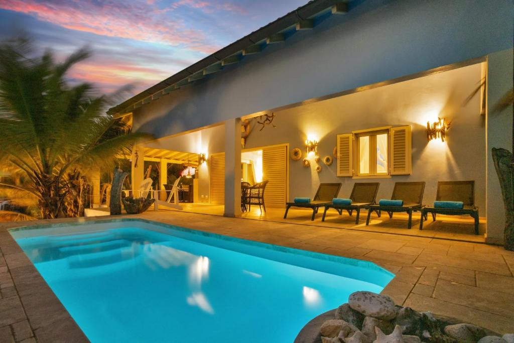 a villa with a swimming pool in front of a house at Caribbean Lofts Villa in Kralendijk