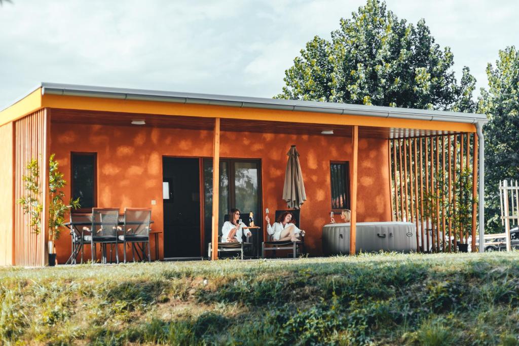 a group of people sitting in a house at Terme Banovci - Mobilne hiške Med Brajdami in Banovci