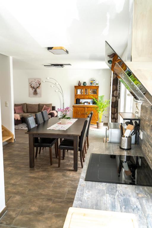 a dining room and living room with a table and chairs at Villa Preisendanz in Ringsheim