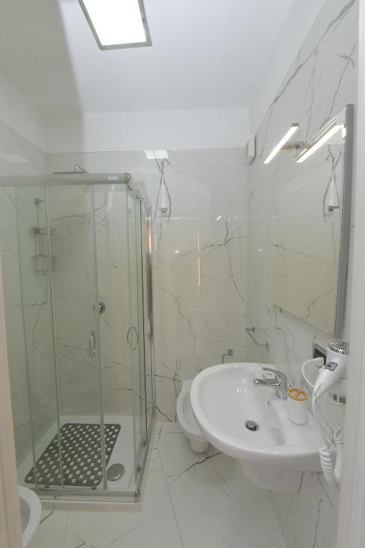 łazienka z przeszkloną kabiną prysznicową i umywalką w obiekcie Noemi B&B w mieście Modugno