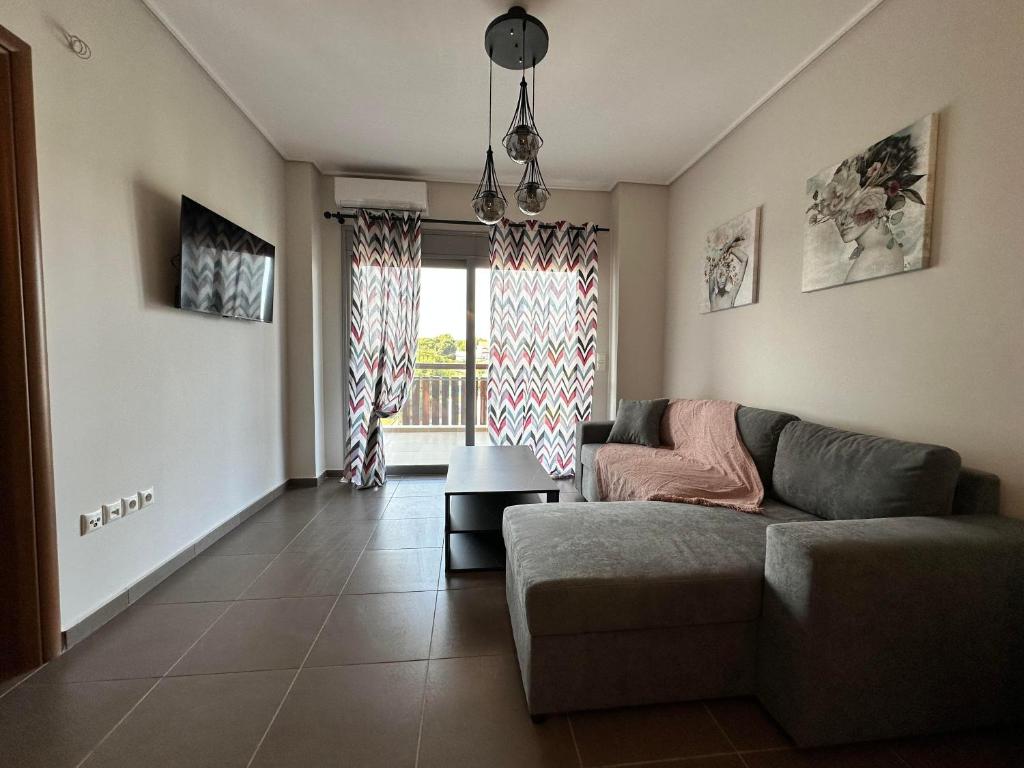 a living room with a couch and a large window at EVa's Luxury Apartments No 4 in Artemida