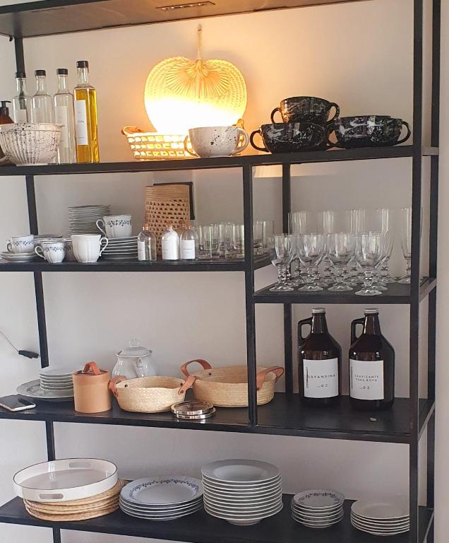 una estantería con platos y copas y botellas de vino en Casa en Golf Club Corrientes en 