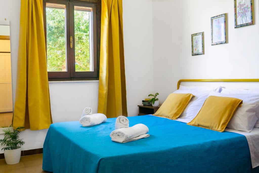 a bedroom with a blue bed with towels on it at [COSTA REI] *500 metri dal mare* Free Parking/Wifi in Costa Rei
