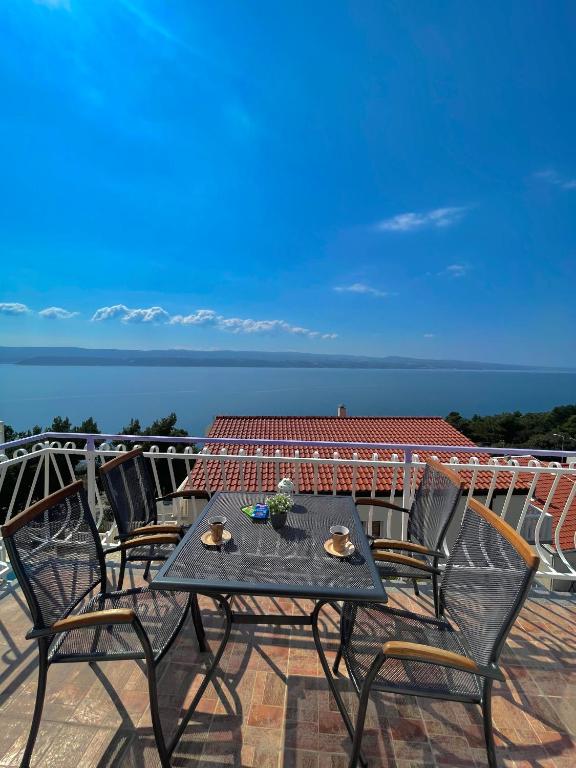 a table and chairs on a balcony with a view of the ocean at Apartmani ABA in Stanići
