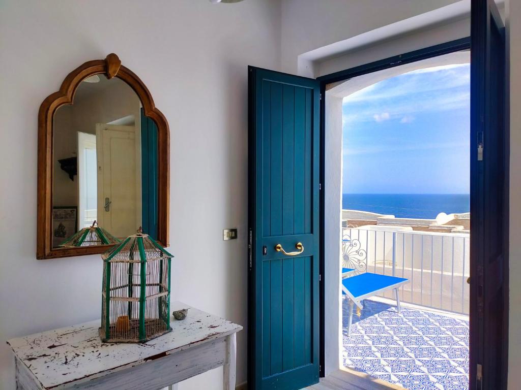 uma porta azul num quarto com vista para o oceano em La Caura di Casa Camilla Journey em Marina Serra