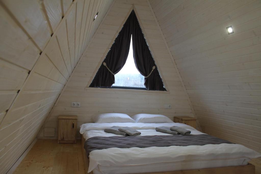 a bedroom with two beds in a attic with a window at Soul House in Pilipets