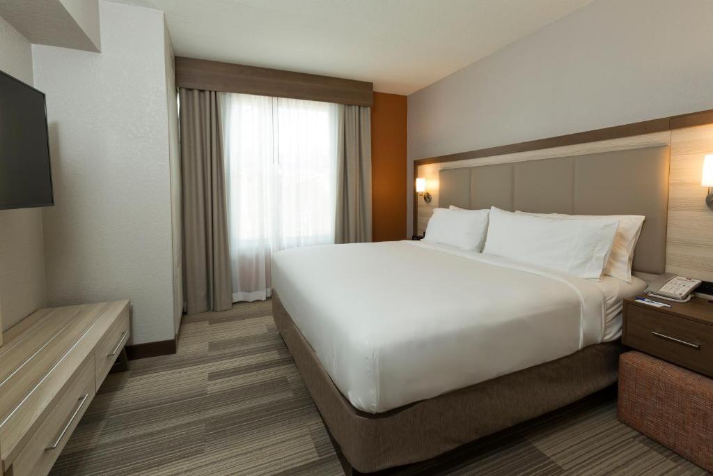 a bedroom with a large white bed and a window at Holiday Inn Express & Suites S Lake Buena Vista by IHG in Kissimmee