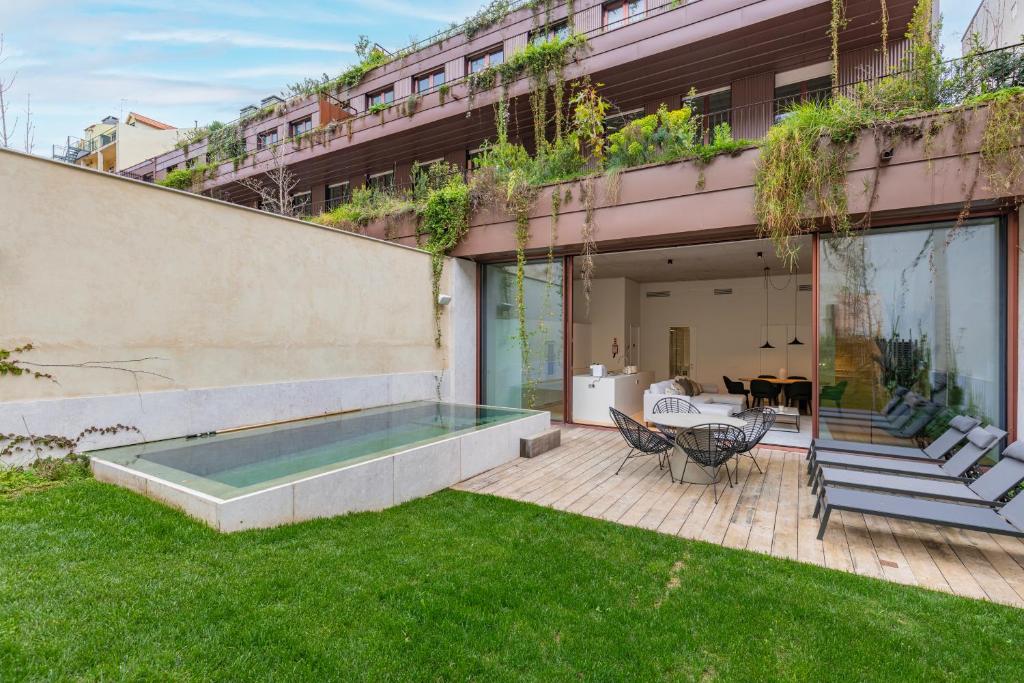 un patio trasero con piscina y césped verde en Hidden Pearl W/ Patio & Pool by LovelyStay en Lisboa