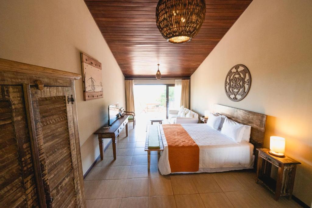 a hotel room with a bed and a living room at Oka Da Mata in Pipa